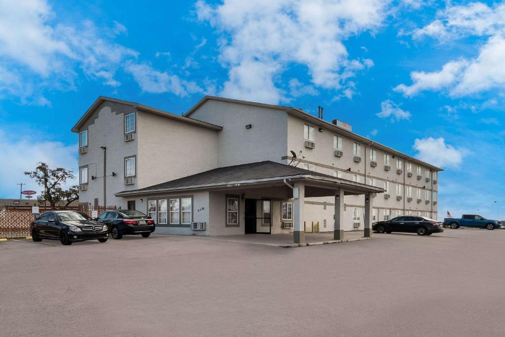 um grande edifício branco com carros estacionados num parque de estacionamento em Econo Lodge San Antonio near SeaWorld - Medical Center em San Antonio