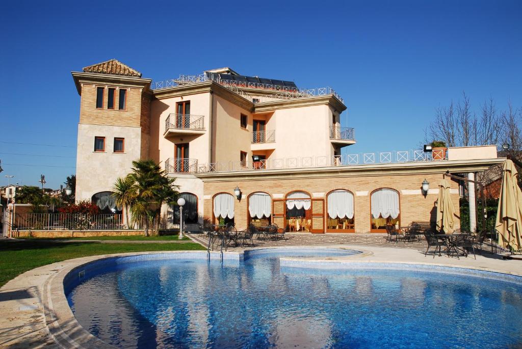 a large house with a swimming pool in front of it at Park Hotel Imperatore Adriano in Tivoli