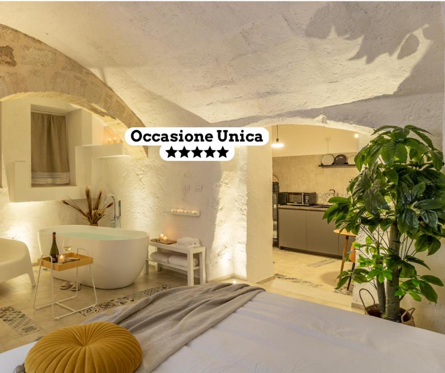 a bedroom with a bed and a tub and a kitchen at Bright Stone con Vasca Jacuzzi in Monopoli