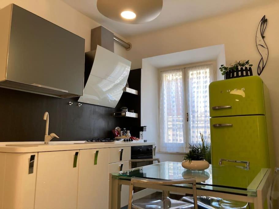 una cucina con frigorifero verde e tavolo in vetro di Casa Iosi a Sirolo a Sirolo