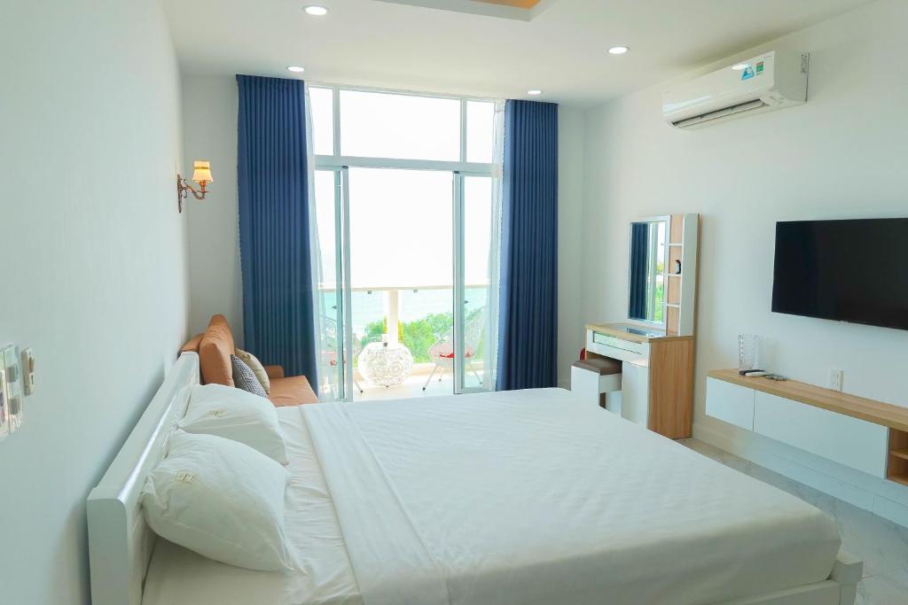 a bedroom with a large bed and a large window at Dương Hằng- Ocean Vista Sealinks in Ấp Ngọc Hải