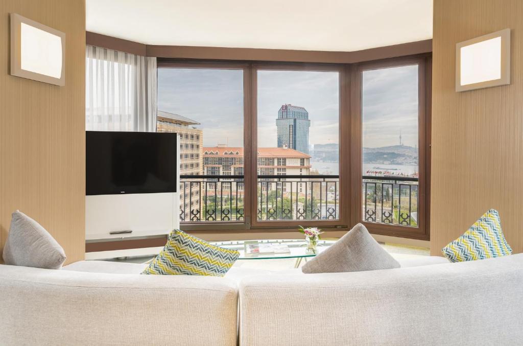 a living room with a couch and a large window at Point Hotel Taksim in Istanbul