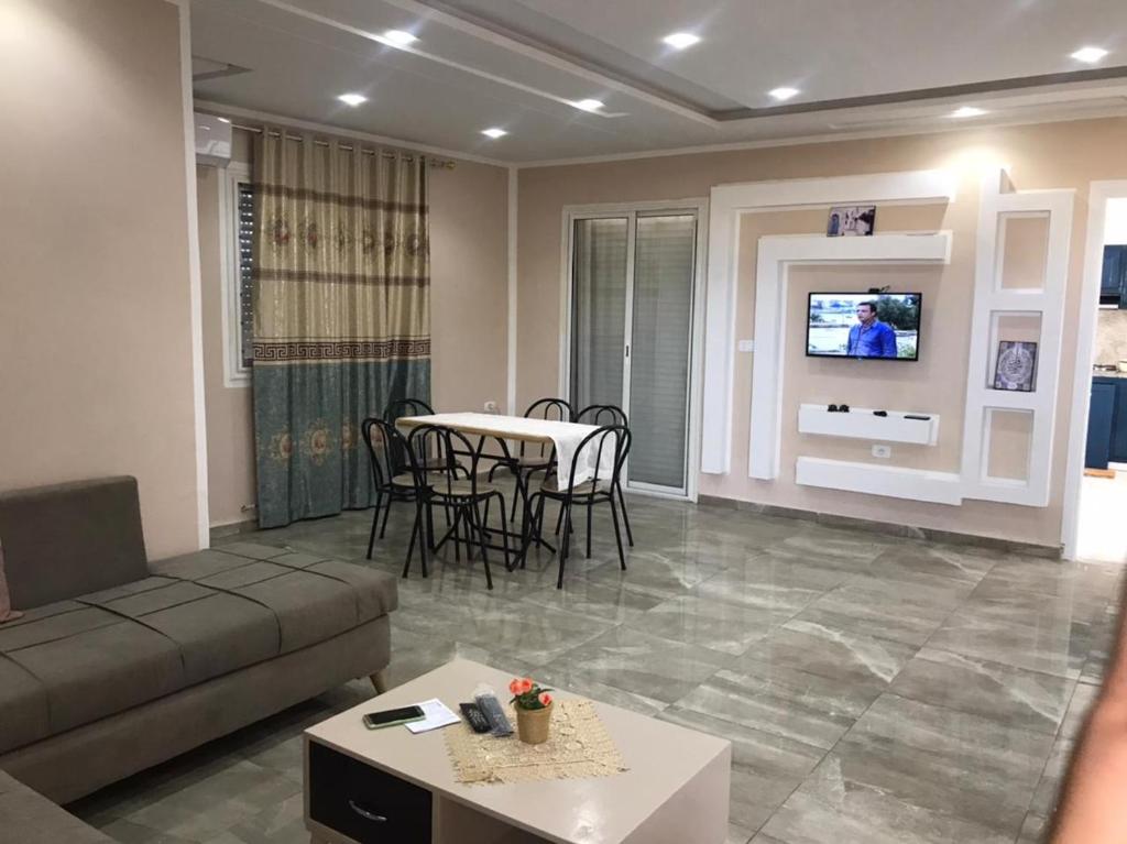 ein Wohnzimmer mit einem Sofa, einem Tisch und einem TV in der Unterkunft Family house in Ḩammām al Ghazzāz