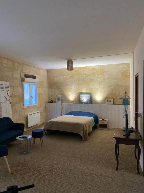 a large bedroom with a bed and a couch at La Beycheliere in Saint-Julien-Beychevelle