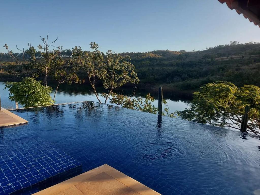 a swimming pool with a view of a river at Suítes Canaã in Capitólio