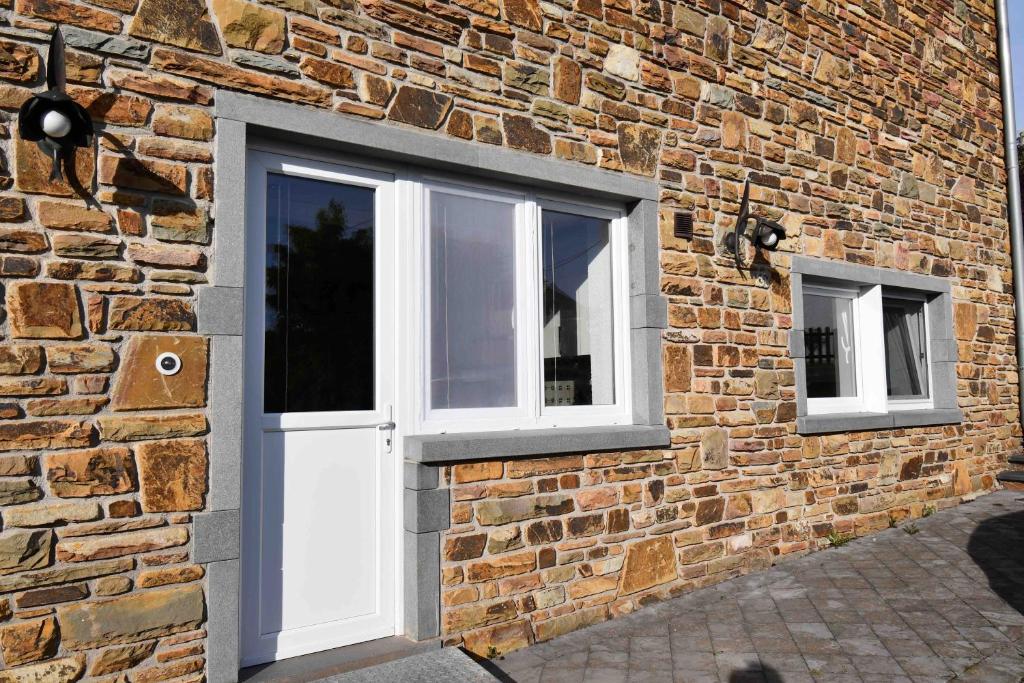 a brick wall with three windows on it at Ferienwohnung für 2 Personen mit direktem Zugang in Auw