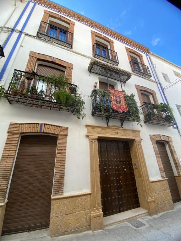 - un bâtiment blanc avec deux portes et deux balcons dans l'établissement Apartamentos turísticos Cambil, à Cambil