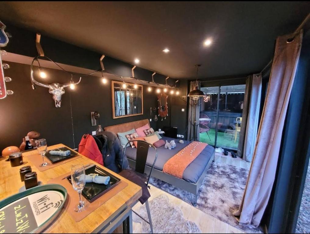 ein Wohnzimmer mit einem Bett und einem Tisch in der Unterkunft L'Ange De Fer in Illoud