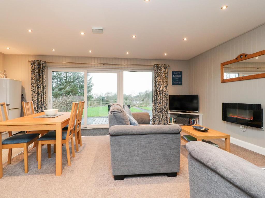 a living room with a couch and a table at Beech Lodge in Preston