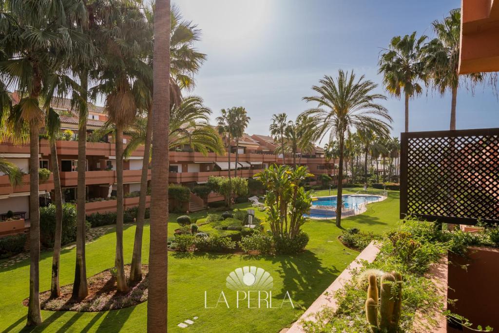 a view of the courtyard of a resort with palm trees at Apartamento La Perla in Marbella
