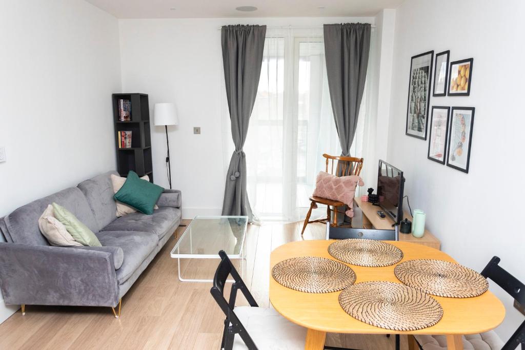 sala de estar con mesa y sofá en Modern Brixton Apartment, en Londres