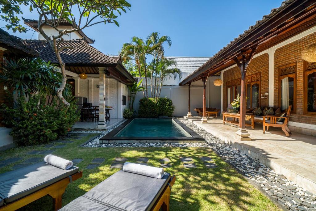 水明漾‎的住宿－Villa Kori Bali Kubu, 9 people maximum, close to Seminyak Beach，一个带游泳池和房子的后院