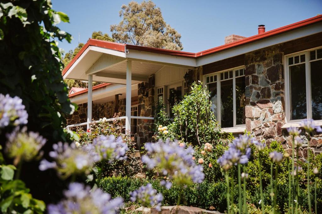 una casa con fiori viola di fronte di Araluen Boutique Accommodation a Yarra Glen