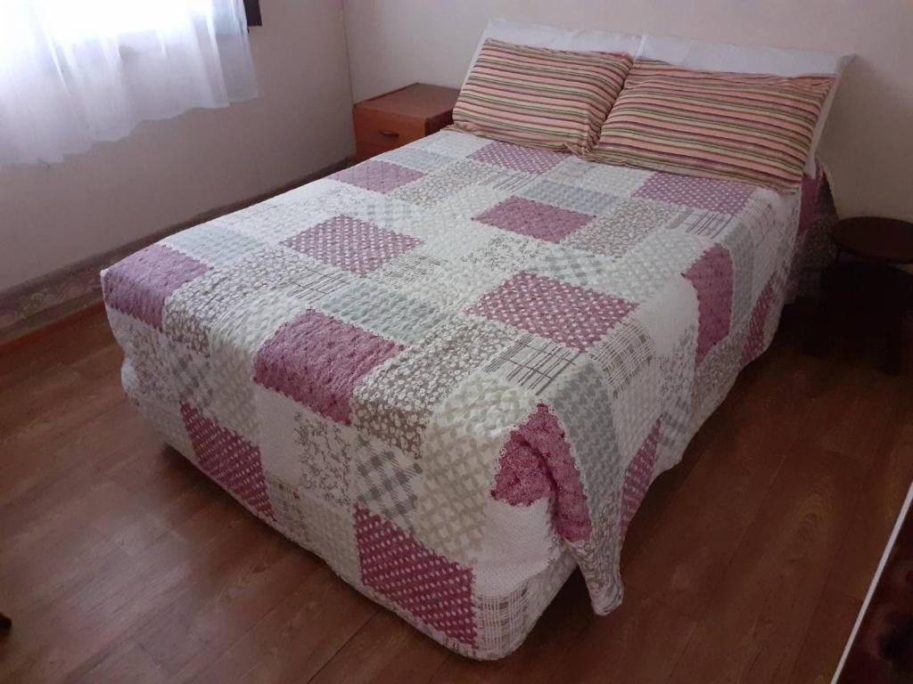 Una cama con edredón en un dormitorio en Cielo Patagónico en Trelew