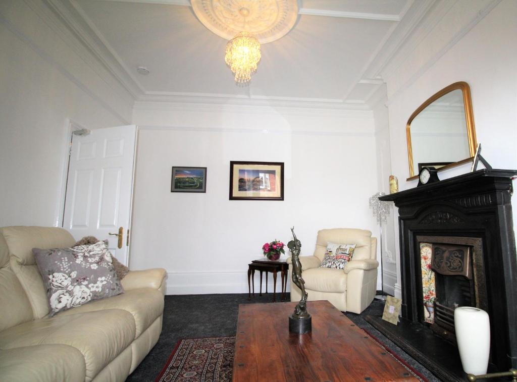 ein Wohnzimmer mit einem Sofa und einem Kamin in der Unterkunft Large Period Property - Beautifully Refurbished in Newcastle upon Tyne
