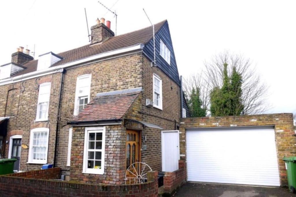a brick house with a white garage door at 3bedroom beautiful cottage in Cheshunt