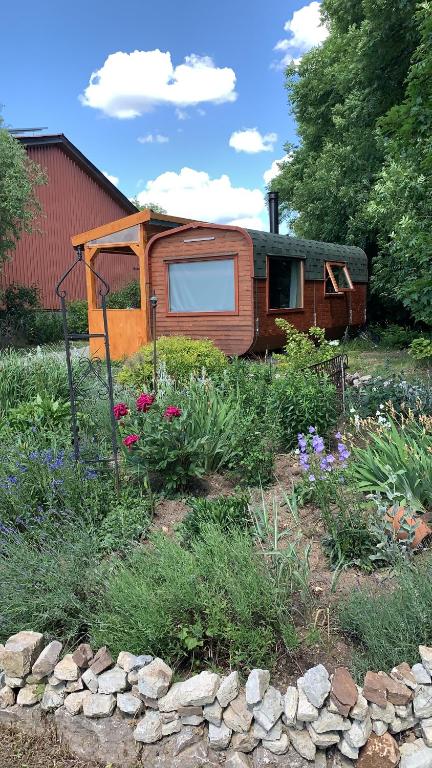 una cabaña en un jardín con flores delante en Irenes Tinyhouse en Markt Nordheim