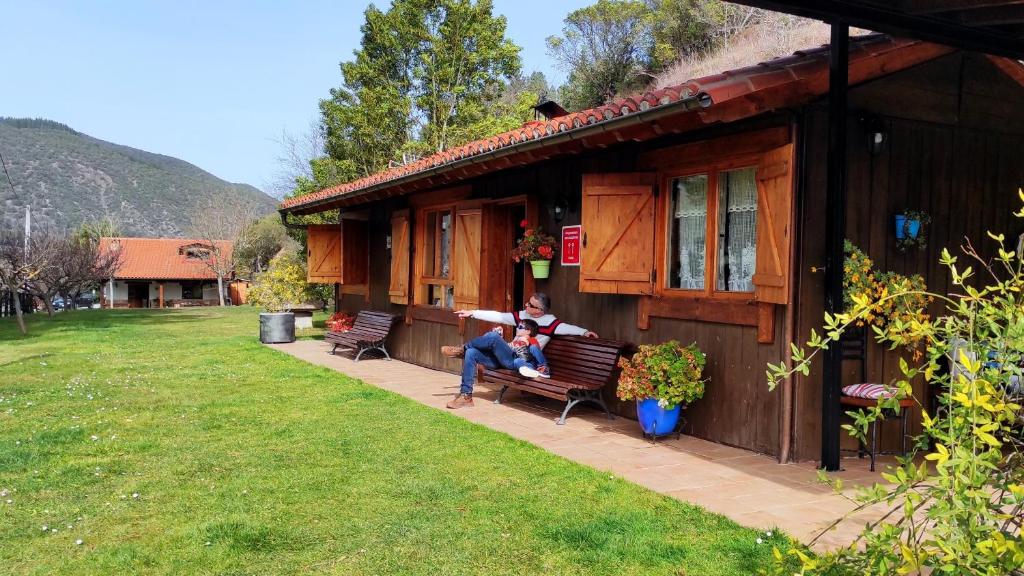 un homme assis sur un banc à l'extérieur d'une maison dans l'établissement Casa Matapalacios, à Potes