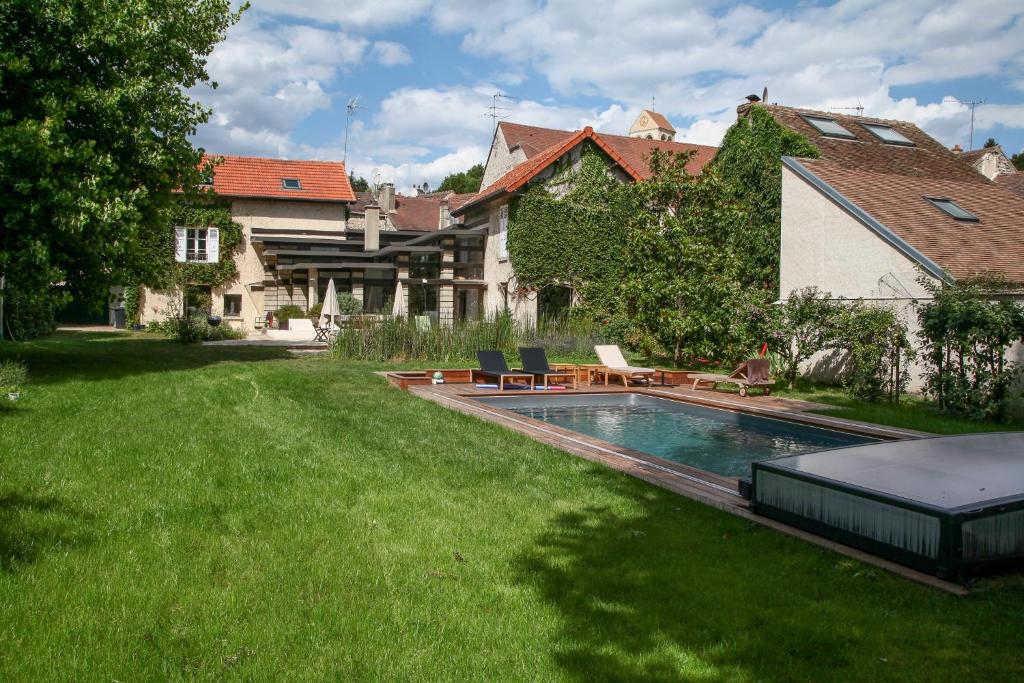 a yard with a swimming pool in front of a house at Le Clos de Gally in Chavenay