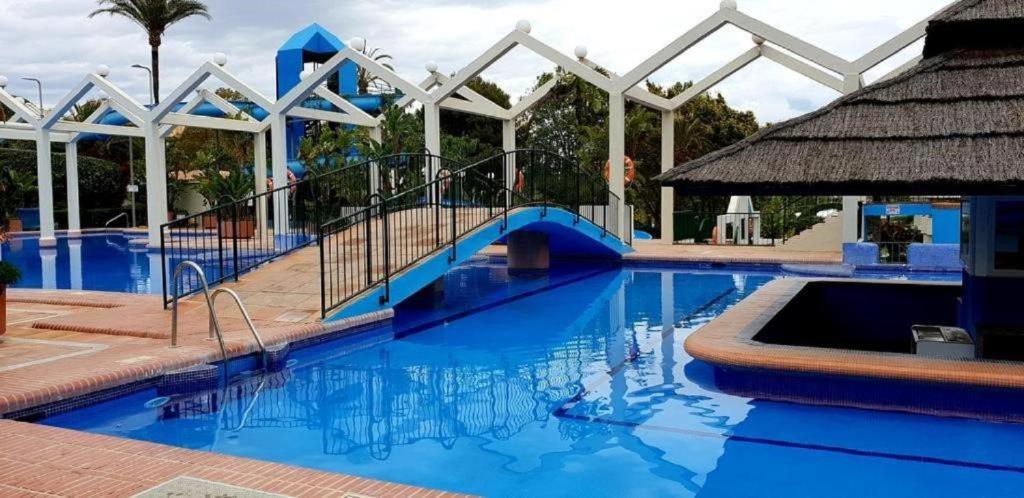 una piscina azul con un tobogán en el medio en PARKING PRIVADO Benalbeach, en Benalmádena
