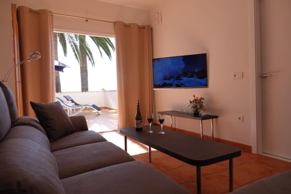 uma sala de estar com um sofá e uma mesa em Schönes Apartment mit Terrasse und Meerblick. em La Matanza de Acentejo