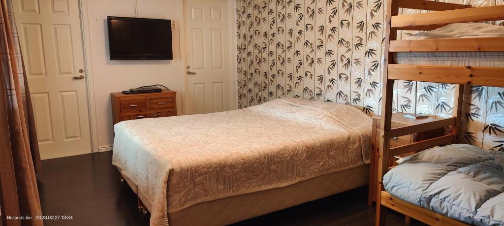 a bedroom with a bunk bed and a tv at Family room in Trönninge