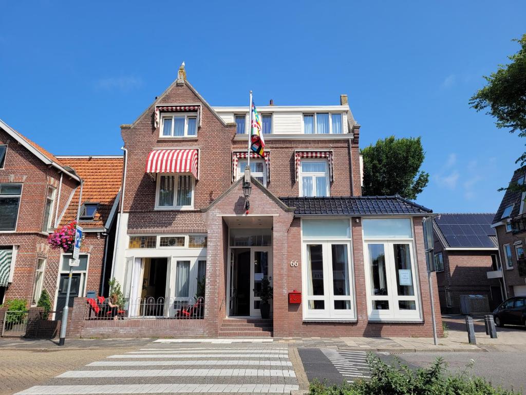ein Backsteingebäude mit amerikanischer Flagge darauf in der Unterkunft Hotel Mare Liberum in Egmond aan Zee