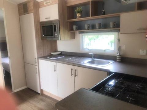 a small kitchen with a sink and a stove at 4 BEDROOMS CARAVAN at Waterside Leisure Holiday Park in Skegness