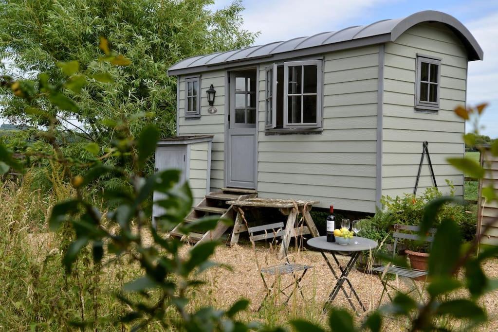 a tiny house in a yard with a picnic table at The Shepherd's Hut @ Chichester Cottage in Chichester
