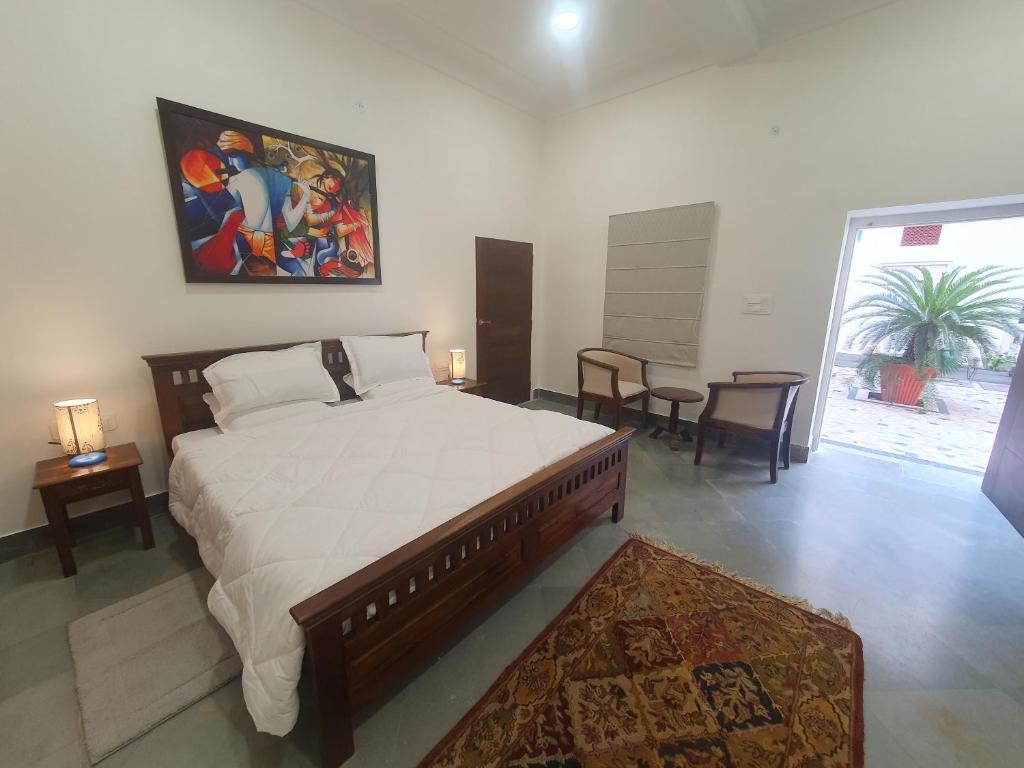um quarto com uma cama grande e uma pintura na parede em Heart of the City Homestay by Rashmi em Jaipur