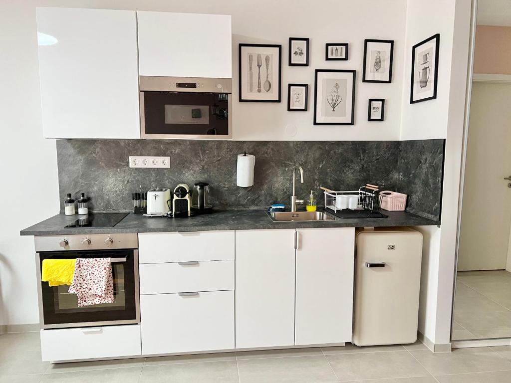 cocina con armarios blancos y encimera en MM D Home Apartment, en Budapest