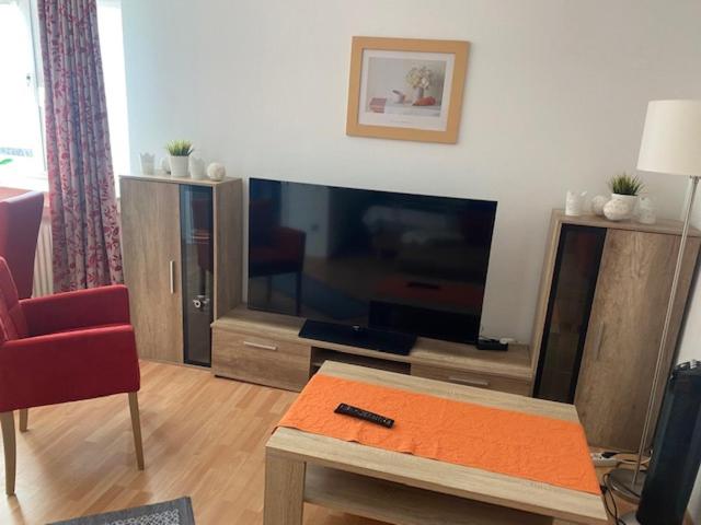 ein Wohnzimmer mit einem großen TV und einem Tisch in der Unterkunft Appartement Leon in Düsseldorf