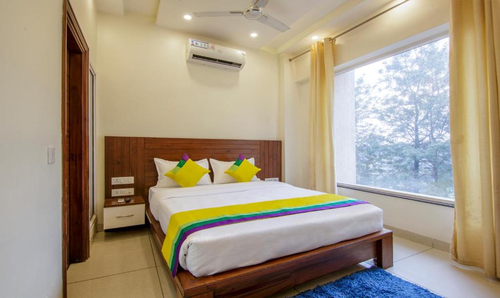a bedroom with a large bed with a window at Itsy By Treebo - GM Residency in Chandīgarh