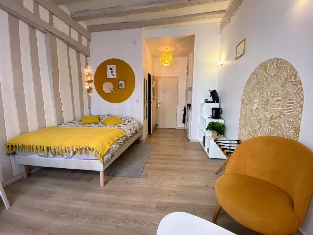 une chambre avec un lit jaune et une chaise dans l'établissement Joli studio hyper centre, à Rouen