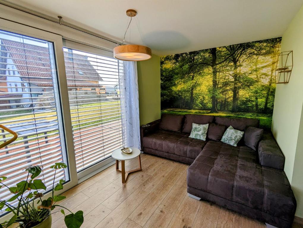 sala de estar con sofá y ventana grande en Ferienhof-Dachsberg Wohnung Paradies, en Bermatingen