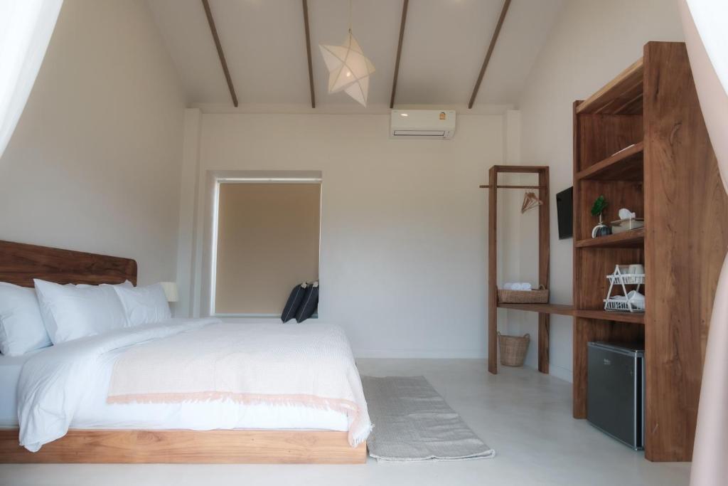 Monko Villa في باي: غرفة نوم بسرير أبيض وخزانة خشبية
