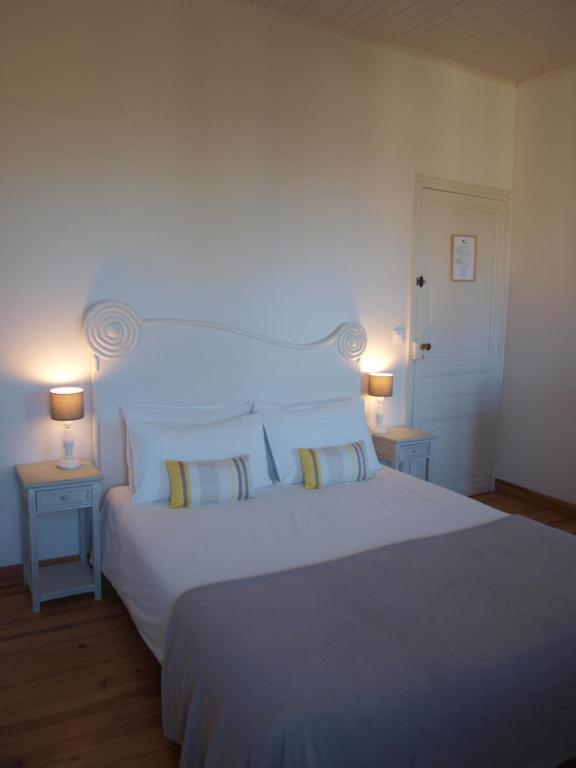 a bedroom with a large white bed with two lamps at L&#39;Estanquet Bed and Breakfast pdj offert in Gastes