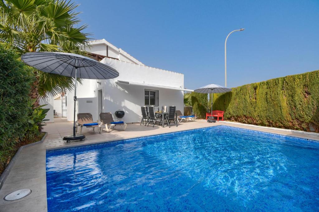 - une piscine avec un parasol à côté d'une maison dans l'établissement El Boticari, à Dénia
