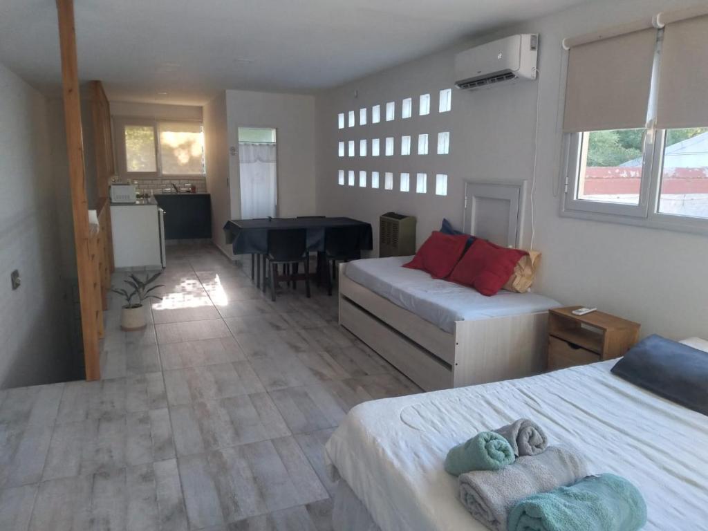 ein Schlafzimmer mit 2 Betten und ein Esszimmer in der Unterkunft Aires de la costa Renovado in Neuquén