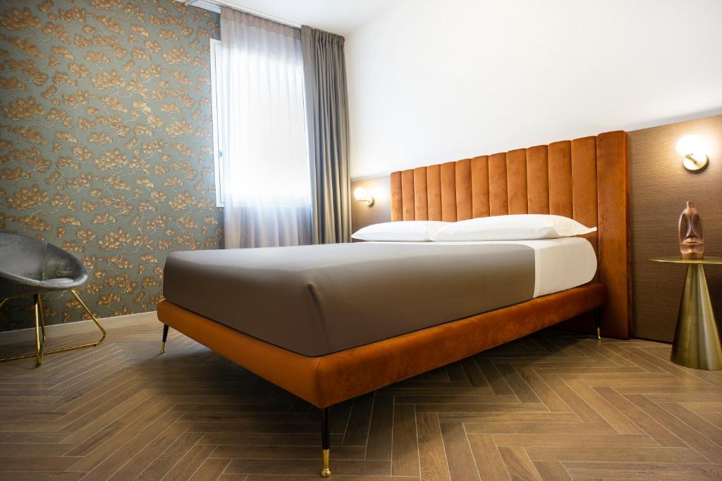 - une chambre avec un grand lit en face d'une fenêtre dans l'établissement Gobetti Apartsuite, à Porto Cesareo