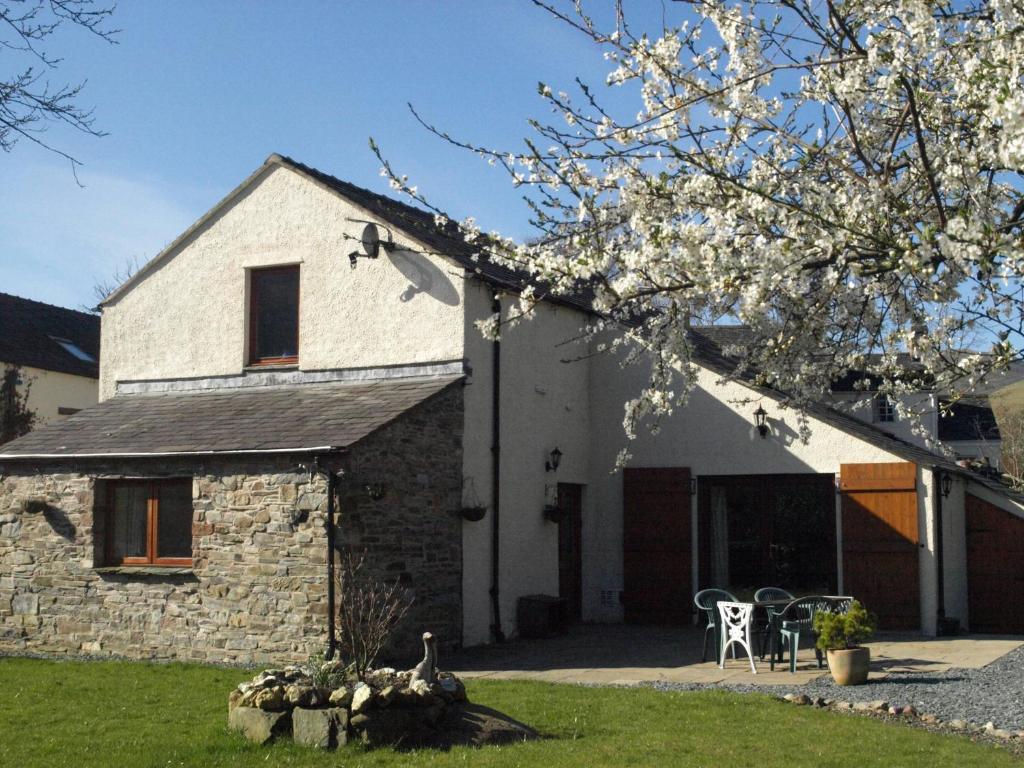 a stone house with a tree in front of it at Damson Ghyll B&B in Loweswater