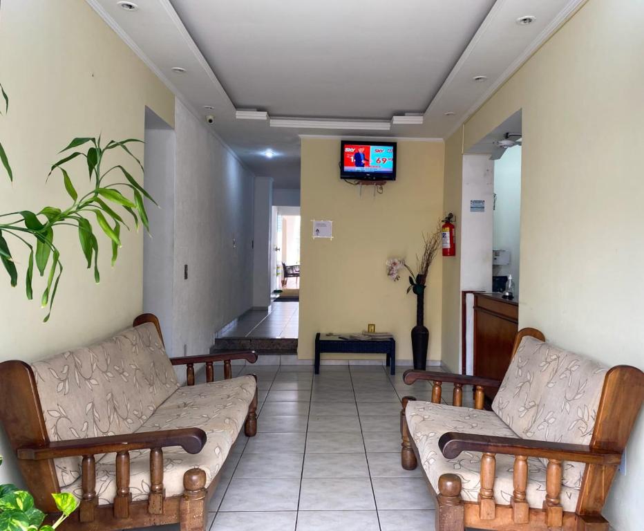 a waiting room with couches and a tv on a wall at Hotel Guarini in Monte Sião