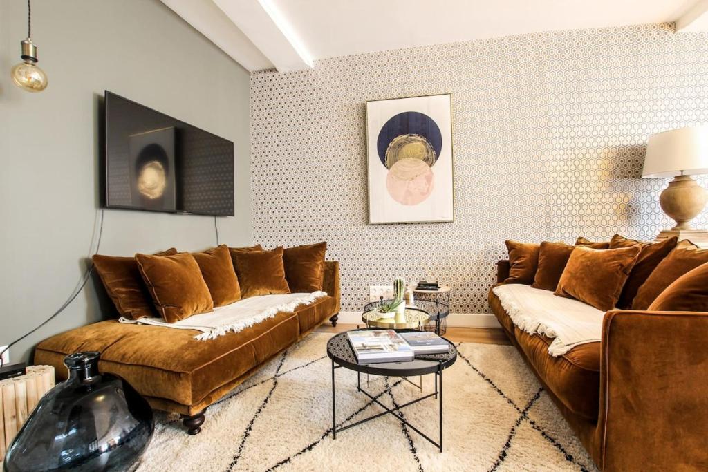 una sala de estar con 2 sofás marrones y una mesa. en La Grande Ferté en La Rochelle