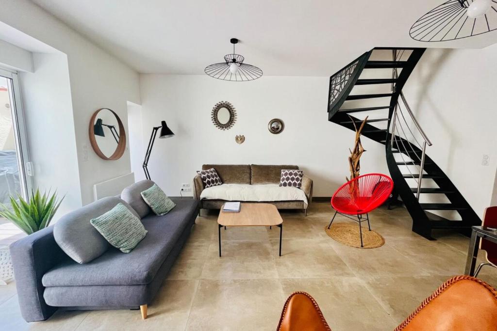 ein Wohnzimmer mit einem Sofa und einer Treppe in der Unterkunft Le Cordouan in La Rochelle