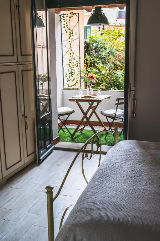 sypialnia z drzwiami prowadzącymi na patio ze stołem w obiekcie Casa Caterina Appartamento al Centro di Taormina w Taominie