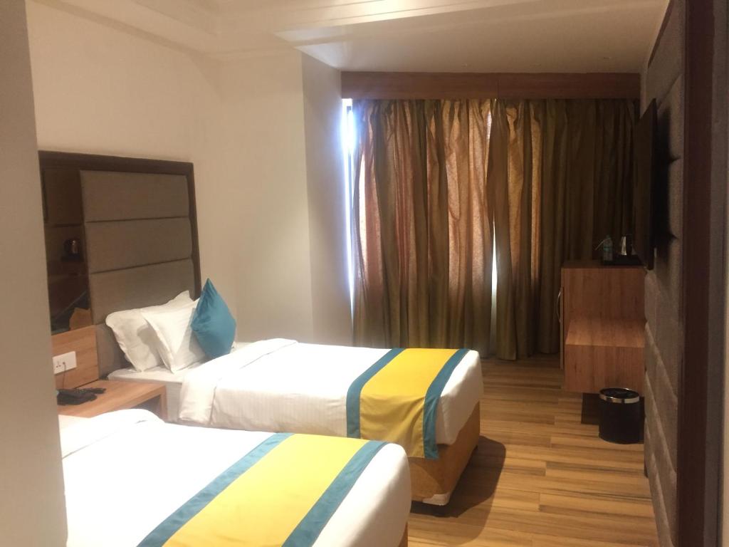 a hotel room with two beds and a window at Arcadia Hotel in Varanasi
