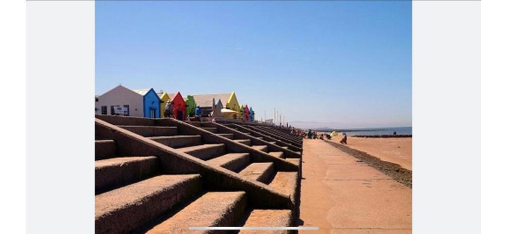 a row of steps on a beach with houses in the background at Seaside chill in Prestatyn