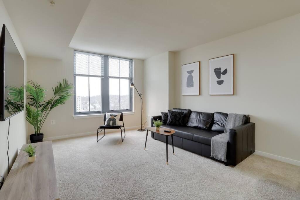 a living room with a black couch and a table at Stunning Apt with Gym at Pentagon City in Arlington