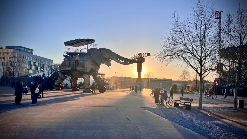 una grande statua di un dinosauro in una strada di città di Chambre D'hôtes sur Île de Nantes a Nantes