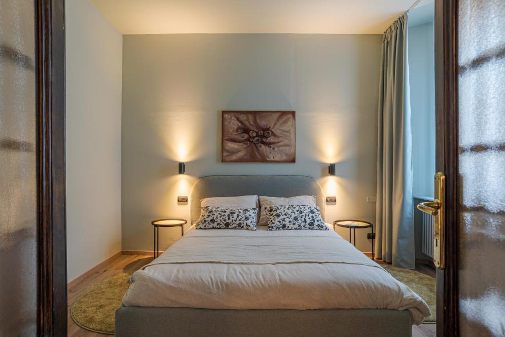 a bedroom with a large bed with two lamps at Cernobbio Charming APT! in Cernobbio